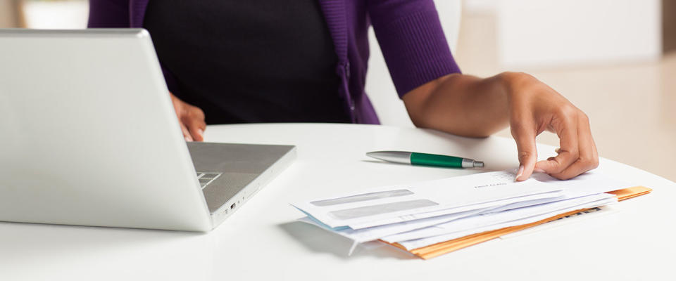 Young woman paying bills on her computer