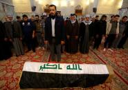 Mourners pray near the coffin of a demonstrator, who was killed at an anti-government protest overnight in Baghdad, during the funeral in the holy city of Najaf,