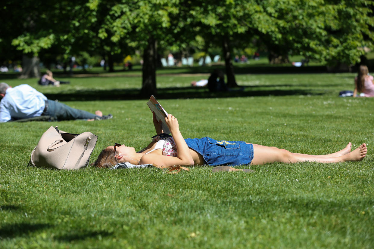 LONDON, UNITED KINGDOM - 2019/05/14: A woman is seen sunbathing and reading a book during a warm and sunny day in London's St James's Park. Temperatures are set to reach 19C in the capital and potentially higher in the some parts of the UK. (Photo by Dinendra Haria/SOPA Images/LightRocket via Getty Images)