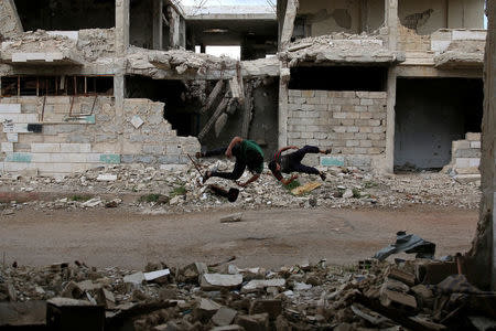 Parkour coach Ibrahim al-Kadiri (L), 19, and Muhannad al-Kadiri, 18, demonstrate their Parkour skills in the rebel-held city of Inkhil, west of Deraa, Syria, April 7, 2017. Members of the group say Parkour takes them away from the atmosphere of war and helps them to take their sorrows away. It unloads their negative energy. REUTERS/Alaa Al-Faqir