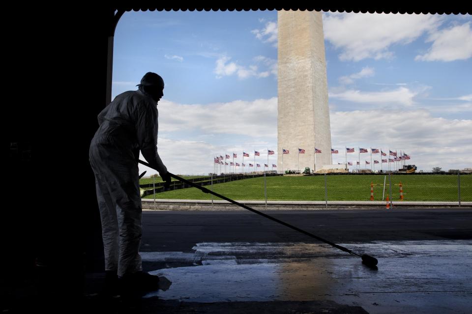 A worker, who asked not to be named, paints the stage of the Sylvan Theater with the Washington Monument in the background, on the National Mall in Washington, Friday, May 2, 2014. The Washington Monument is scheduled to reopen May 12 after earthquake damages were repaired. For years, the mall's grounds and facilities have fallen into disrepair, even though it's is the most-visited national park. Visitors often find dead grass, broken sidewalks and fetid pools of water. (AP Photo/Jacquelyn Martin)