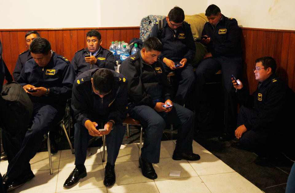 Air Force members check their cell phones after protesting for a second day, as they rest at the headquarters of the National Association of Warrant Officers and Sergeants in La Paz, Bolivia, Wednesday, April 23, 2014. Hundreds of low ranking soldiers from Bolivia's Armed Forces marched for a second day against the military high command's dismissal of four of its leaders who defended their call for more career opportunities. The Ministry of Defense has threatened to discharge the soldiers who continue to protest. (AP Photo/Juan Karita)