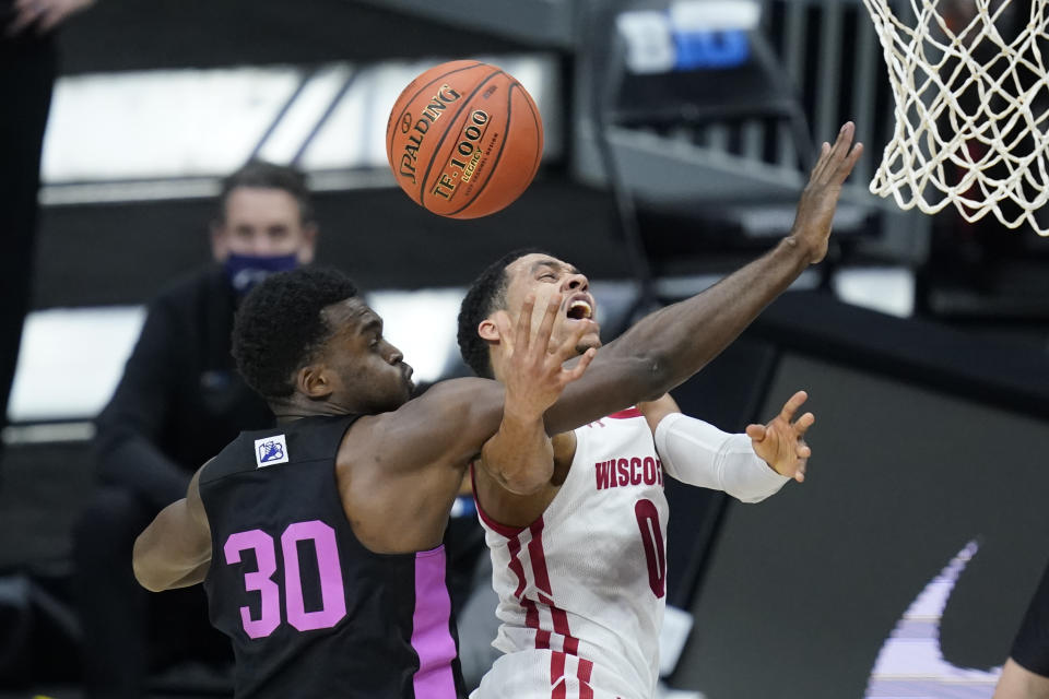 Wisconsin's D'Mitrik Trice (0) is fouled by Penn State's Abdou Tsimbila (30) as he goes up for a shot during the first half of an NCAA college basketball game at the Big Ten Conference tournament, Thursday, March 11, 2021, in Indianapolis. (AP Photo/Darron Cummings)