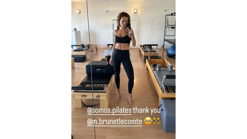 Rita Ora poses in a pilates studio wearing leggings and a sports bra