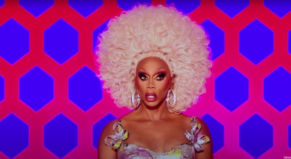 Ru has big blonde hair on the set of drag race