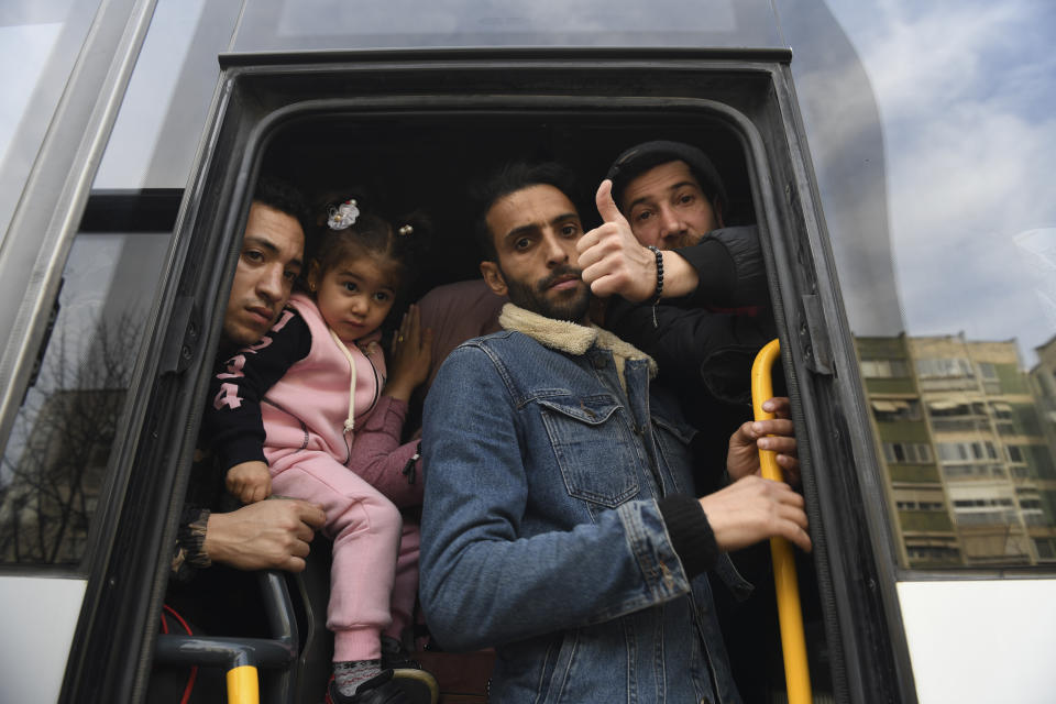 Migrants board a bus to go to the Greek border, in Istanbul, Friday, Feb. 28, 2020. NATO envoys were holding emergency talks Friday at the request of Turkey following the killing of 33 Turkish soldiers in northeast Syria, as scores of migrants gathered at Turkey's border with Greece seeking entry into Europe. (AP Photo/Omer Kuscu)