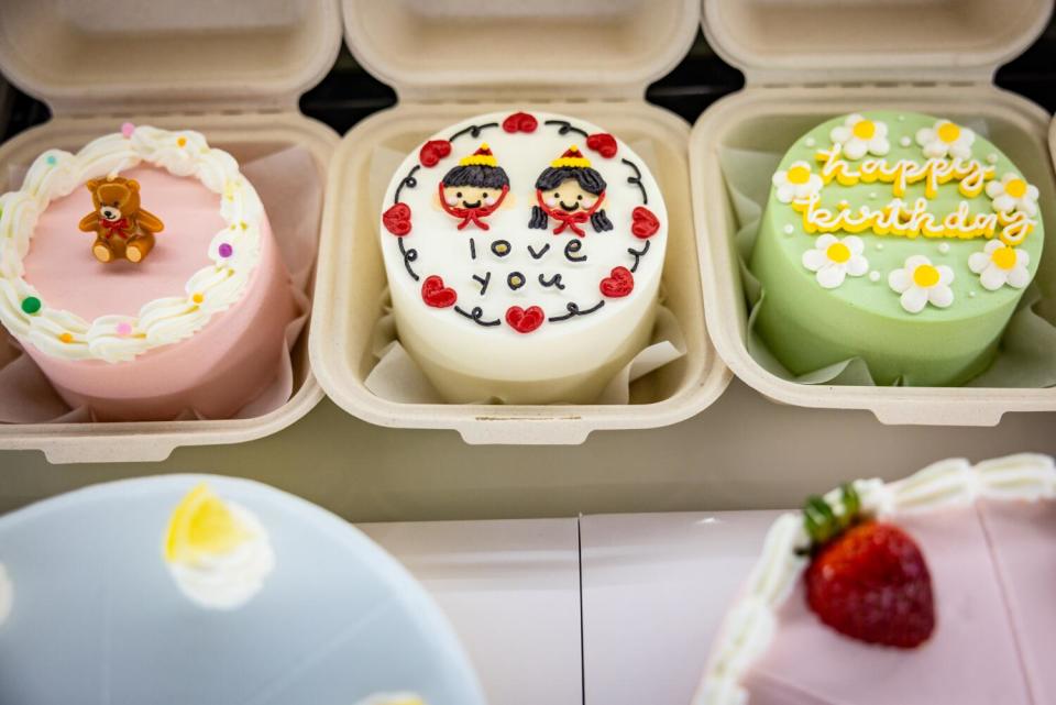 Decorated mini bento cakes in a case at Harucake.