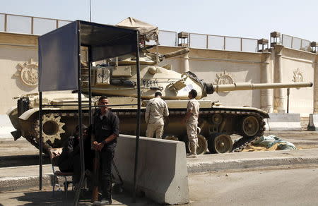 Police and army soldiers are seen in front of a tank as they guard outside Tora prison, where Al Jazeera television journalists Mohamed Fahmy and Baher Mohamed were held and are having their retrial, in Cairo, Egypt, July 30, 2015. REUTERS/Asmaa Waguih