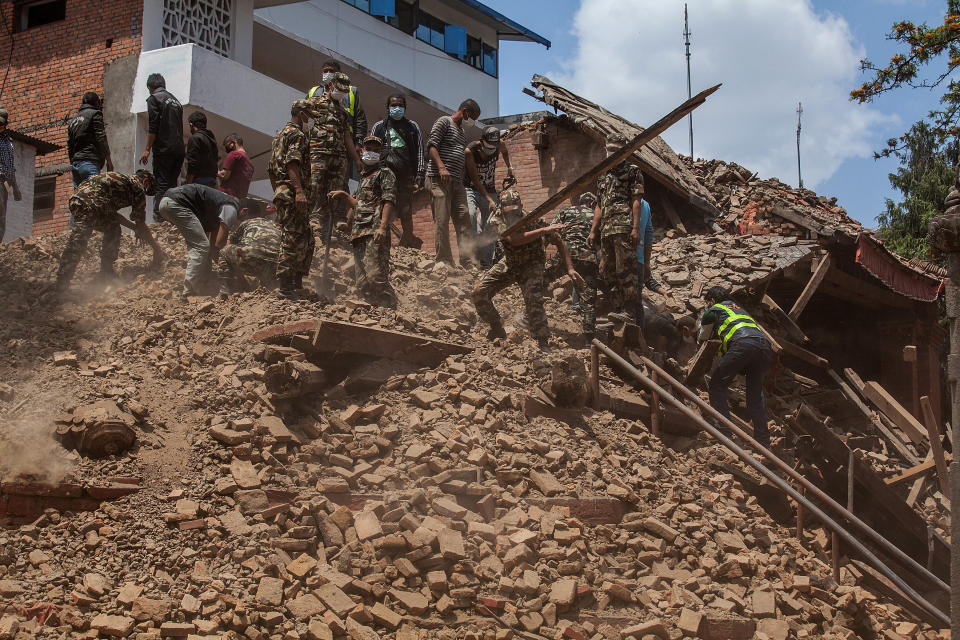 Volunteers and rescue team members clear debris of a collapsed temple at Basantapur Durbar Square on April 27, 2015 in Kathmandu, Nepal. (Photo by Omar Havana/Getty Images)