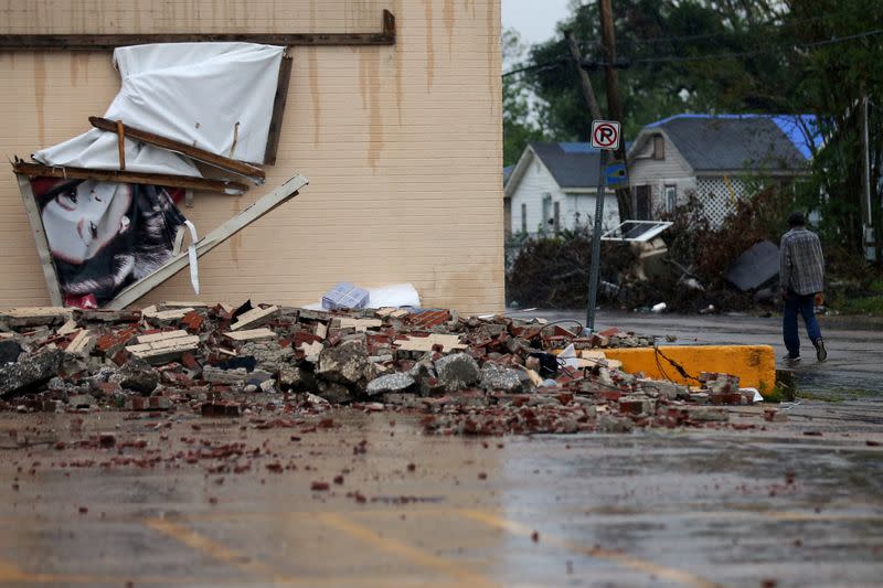 FILE PHOTO: A man walks past a building that was damaged by Hurricane Laura as Hurricane Delta approaches in Lake Charles