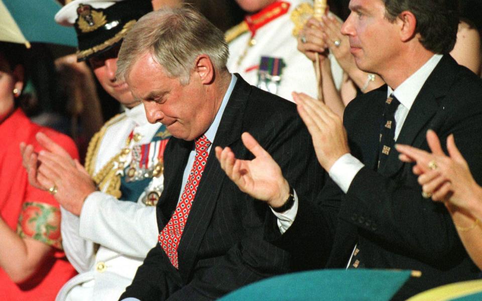 Outgoing Hong Kong Governor Chris Patten (C) choking back tears after making his farewell speech at the former headquarters of the British forces in Hong Kong as Britain's Prince Charles (L) and British Prime Minister Tony Blair (R) look on - Credit: AFP