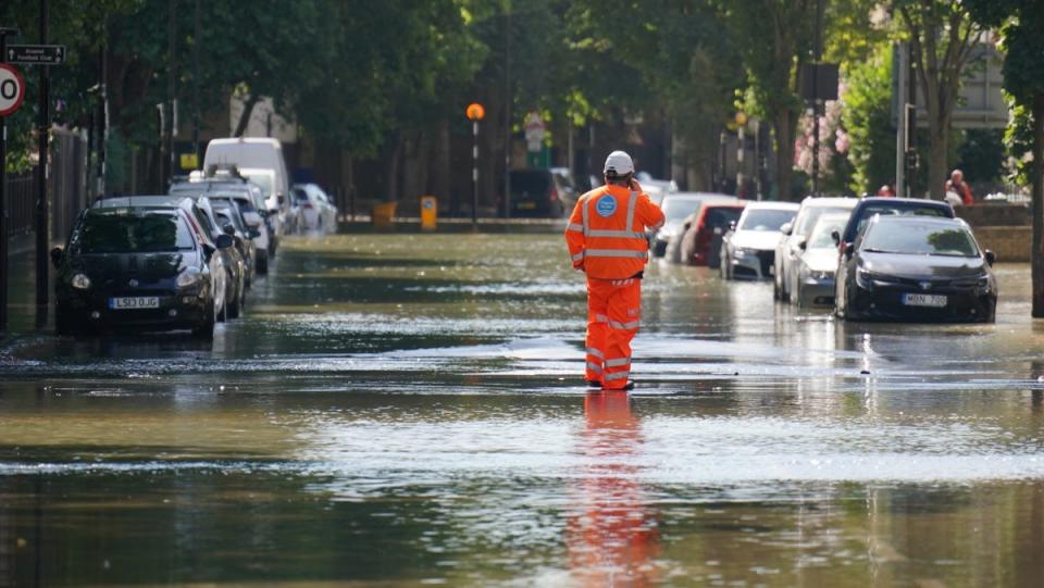 A Thames Water official stands in flood water on Hornsey Road, Holloway, north London, after a 36in water main burst (Jonathan Brady/PA Wire)