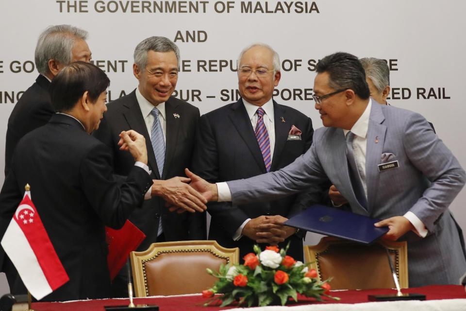Singapore Coordinating Minister for Infrastructure and Minister for Transport Khaw Boon Wan, left, Singapore's Prime Minister Lee Hsien Loong, second from left, and Malaysia's Prime Minister Najib Razak second from right, and Malaysia's Minister in the Prime Minister's Department Abdul Rahman Dahlan greeting each other after a signing ceremony of agreement on the Kuala Lumpur-Singapore High Speed Rail (HSR) project in Putrajaya, Malaysia, Tuesday, Dec. 13, 2016. Malaysia and Singapore today signed the long-awaited agreement on the Kuala Lumpur-Singapore High Speed Rail (HSR) project. (AP Photo/Vincent Thian)