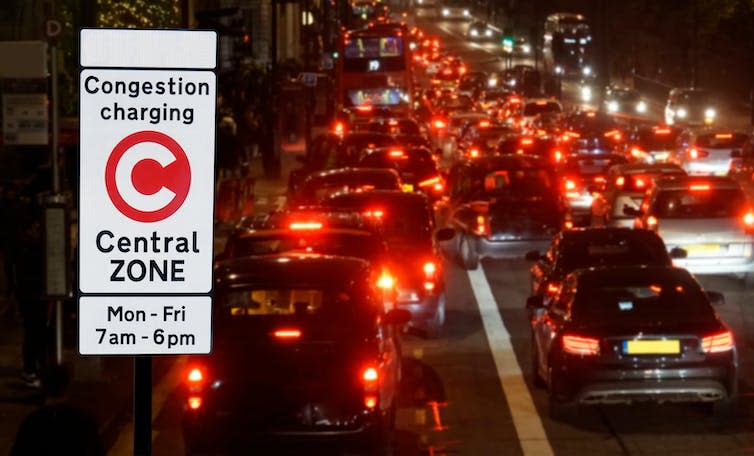 Congestion charge sign and traffic at night