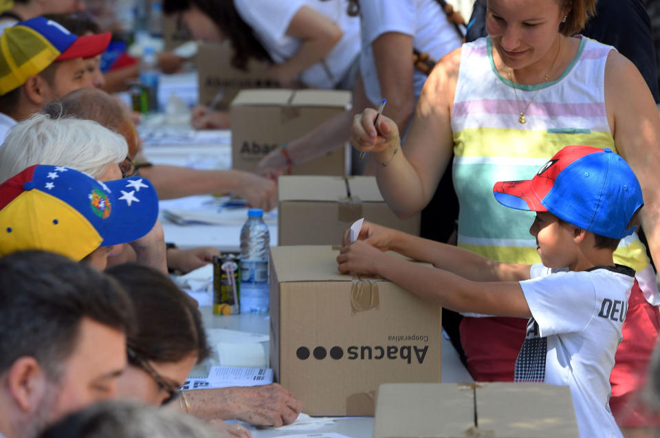 <p>A child casts a ballot during a symbolic plebiscite on Venezuelan president Maduro’s project of a future constituent assembly, called by the Venezuelan opposition and held in Barcelona on July 16, 2017. (Lluis Gene /AFP/Getty Images) </p>