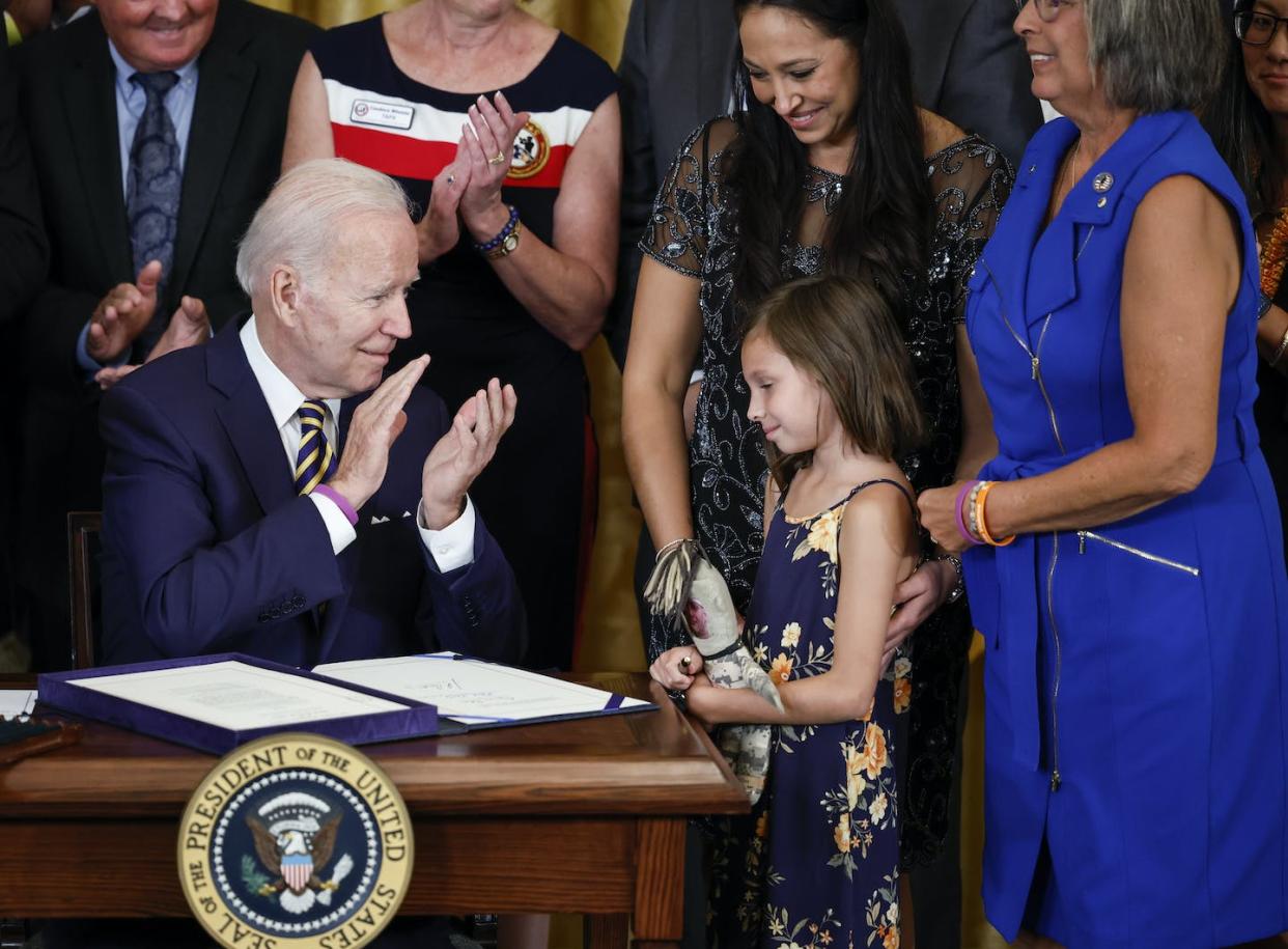 President Joe Biden applauds Brielle Robinson, daughter of the late Sgt. First Class Heath Robinson, after signing the PACT Act on Aug. 10, 2022. <a href="https://www.gettyimages.com/detail/news-photo/president-joe-biden-applauds-and-acknowledges-brielle-news-photo/1242419232?adppopup=true" rel="nofollow noopener" target="_blank" data-ylk="slk:Chip Somodevilla/Getty Images;elm:context_link;itc:0;sec:content-canvas" class="link ">Chip Somodevilla/Getty Images</a>