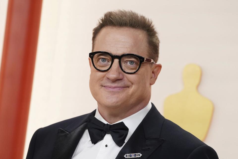 Brendan Fraser, nominado a mejor actor, sonrí sutilmente la lente en al alfombra.