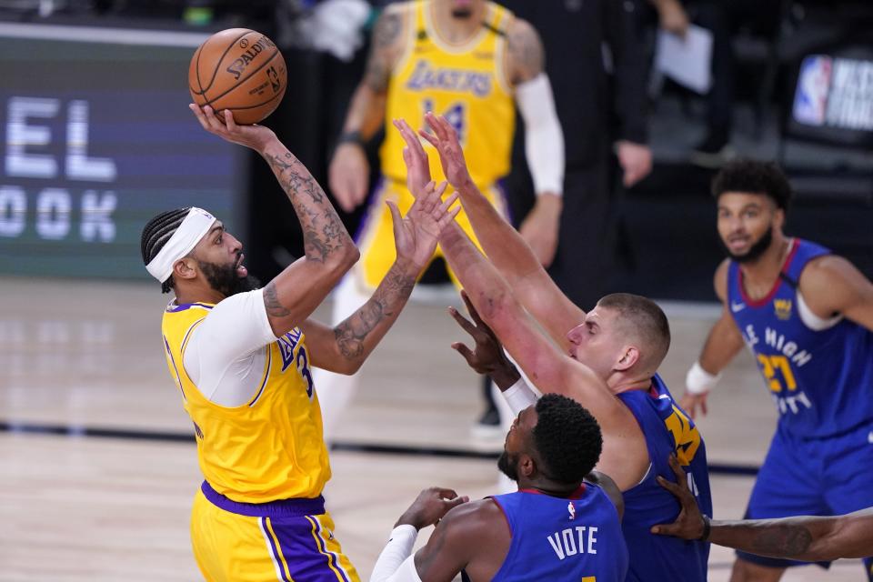 Los Angeles Lakers forward Anthony Davis, left, attempts a shot over Denver Nuggets' Paul Millsap, bottom front, Nikola Jokic, bottom center, and Jamal Murray (27) during the second half an NBA conference final playoff basketball game, Friday, Sept. 18, 2020, in Lake Buena Vista, Fla. (AP Photo/Mark J. Terrill)