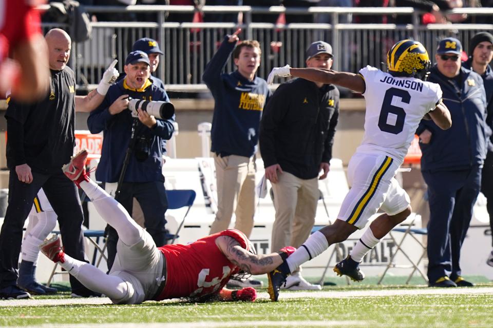 Michigan receiver Cornelius Johnson avoids a tackle by Ohio State defensive end Jack Sawyer on his way to a 69-yard touchdown.