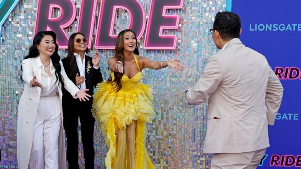 Ashley Park reaches to embrace Daniel Dae Kim at the “Joy Ride” premiere as Sherry Cola and director Adele Lim look on (Credit: Getty Images)