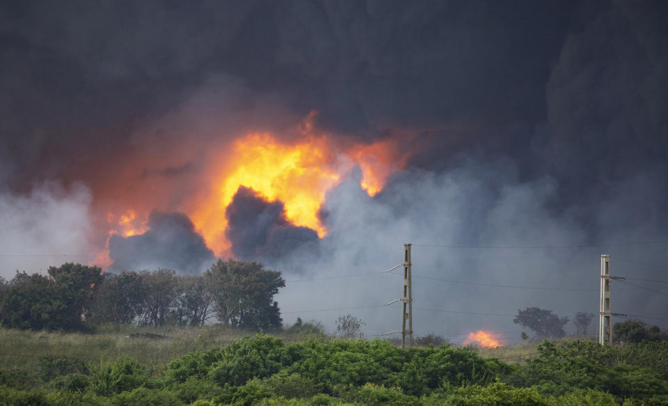 Flames and smoke rise from the Matanzas Supertanker Base as firefighters work to quell the blaze which began during a thunderstorm in Matanzas, Cuba, Monday, Aug. 8, 2022. Cuban authorities say lightning struck a crude oil storage tank at the base, sparking a fire that sparked four explosions. (AP Photo/Ismael Francisco)