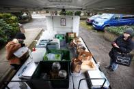 Ella Shone, serves a customer from her mobile zero waste shop called the 'Top Up Truck' in London