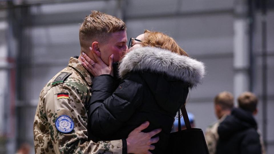 A German armed forces Bundeswehr soldier who had served under the UN mission in Mali, MINUSMA, kisses his partner after he landed at the military air base in Wunstorf, northern Germany, on December 15, 2023.