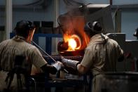 Employees pour liquid gold into a mould for the production of an ingot during the refining process at AGR (African Gold Refinery) in Entebbe