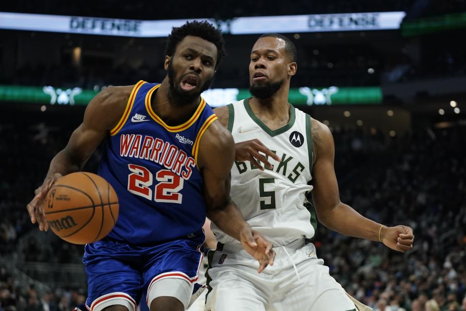 Golden State Warriors' Andrew Wiggins tries to drive past Milwaukee Bucks' Rodney Hood during the first half of an NBA basketball game Thursday, Jan. 13, 2022, in Milwaukee. (AP Photo/Morry Gash)