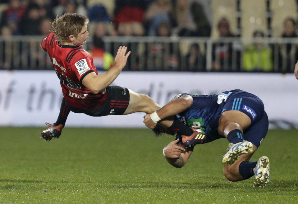 Crusaders Jack Goodhue, left, is airborne as he is tackled by Blues Levi Aumua during their Super Rugby match in Christchurch, New Zealand, Saturday, May 25, 2019. (AP Photo/Mark Baker)