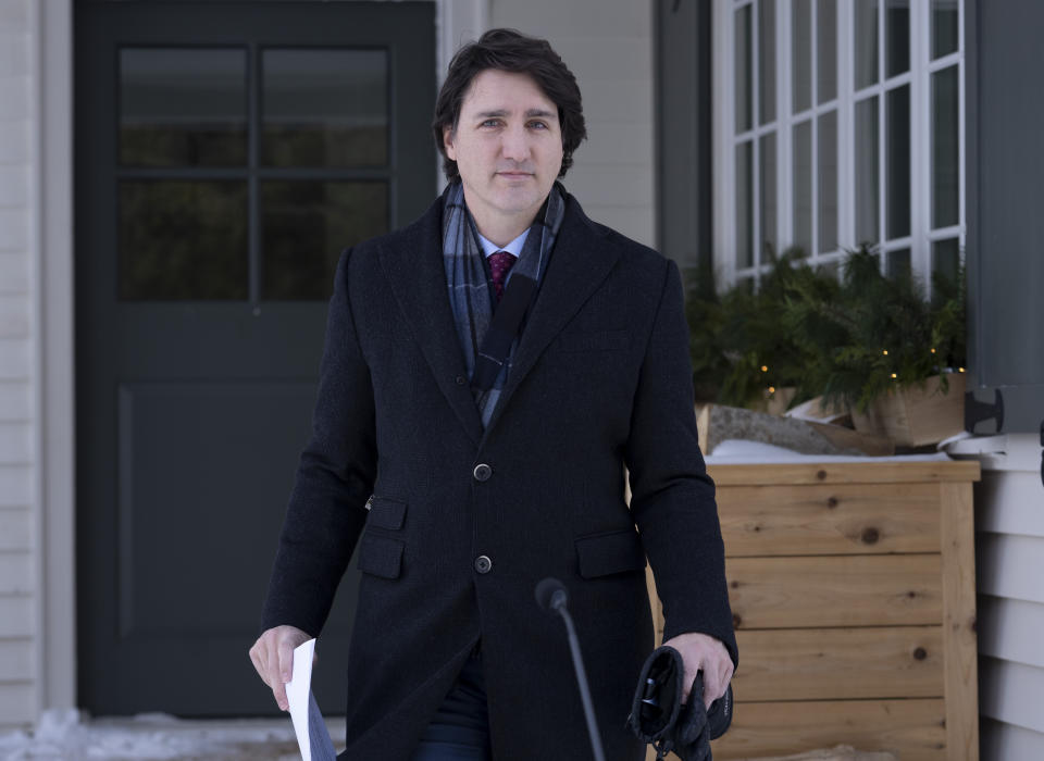 FILE - Canadian Prime Minister Justin Trudeau steps out of a building to speak with the media during his first availability after announcing he has COVID-19 at a location in the National Capital Region, Monday, Jan. 31, 2022. On Friday, Feb. 4, The Associated Press reported on stories circulating online incorrectly claiming Trudeau has been “hiding out” in the U.S. as a convoy of truckers and protesters demonstrate against vaccine mandates in Ottawa. (Adrian Wyld/The Canadian Press via AP, File)