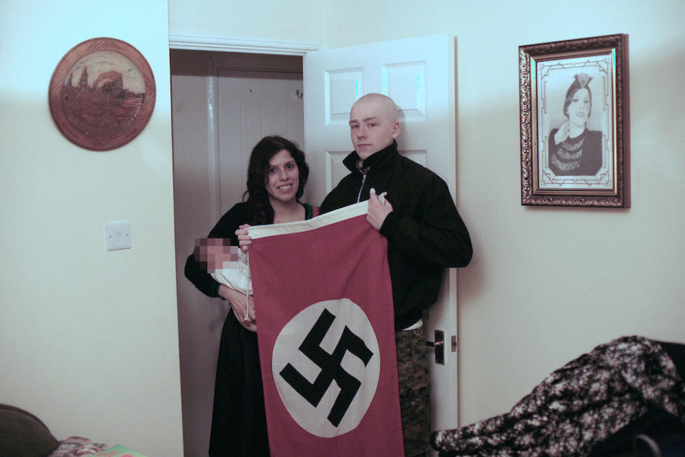 Adam Thomas and his partner Claudia Patatas, pictured holding a swastika and their newborn baby (Picture: PA)