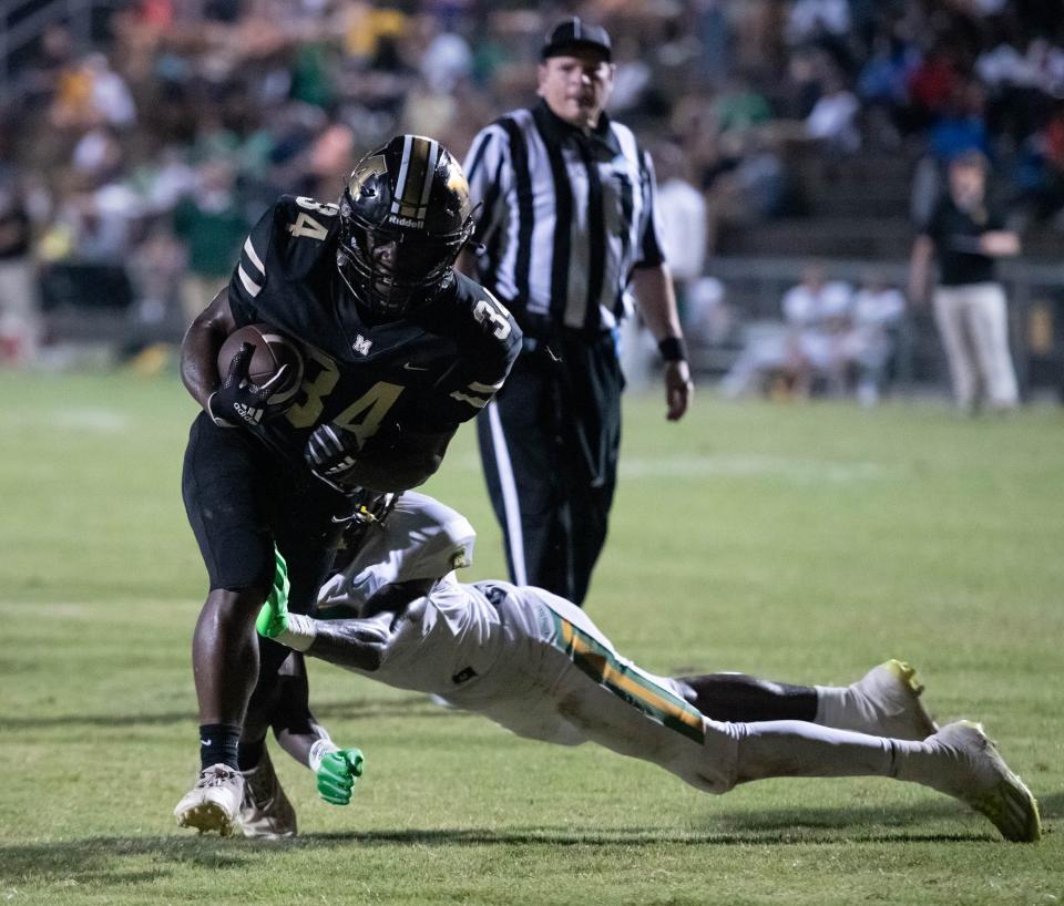 Jwilliam Grimsley (34) bulls his way to just short of the end zone setting up a 1st and goal for the Panthers during the Pensacola Catholic vs Milton football game at Milton High School on Thursday, Sept. 1, 2022.