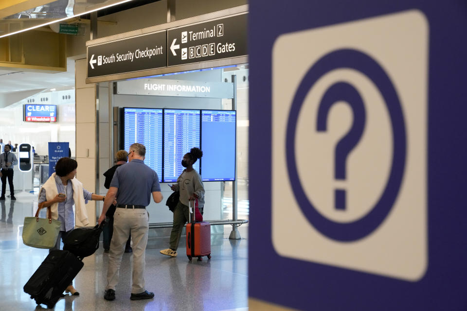 Travelers walk through Ronald Reagan Washington National Airport in Arlington, Va., Wednesday, Nov. 23, 2022. (AP Photo/Patrick Semansky)