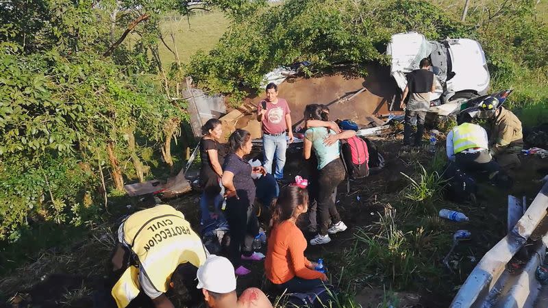 Migrants are treated by first responders following a crash on a highway in San Andres Tuxtla