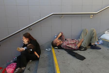 Migrants rest on the steps to an underground station near the main Eastern Railway station in Budapest, Hungary, September 1, 2015. Hundreds of angry migrants demonstrated outside Budapest's Eastern Railway Terminus on Tuesday demanding they be allowed to travel on to Germany, as the biggest ever influx of migrants into the European Union left its asylum policies in tatters. Around 1,000 people waved tickets, clapping, booing and hissing, and shouting "Germany! Germany!" outside the station. A refugee crisis rivalling the Balkan wars of the 1990s as Europe's worst since World War Two has polarised and confounded the European Union, which has no mechanism to cope with the arrival of hundreds of thousands of poor and desperate people. REUTERS/Laszlo Balogh