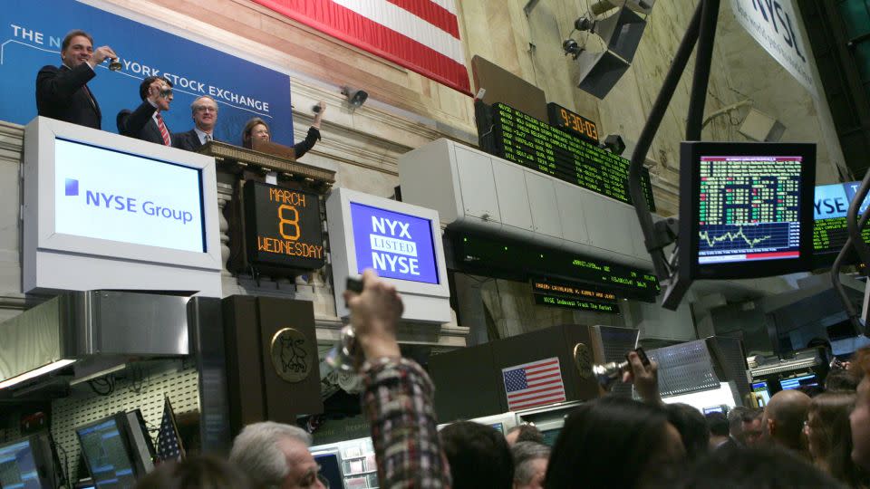 From left to right on balcony, Gerald Putnam, CEO of Archipelago Holdings, John Thain, CEO of the New York Stock Exchange, Marshall Carter, Chairman of the NYSE, and Catherine Kinney, President and co-COO of the NYSE, celebrate the listing of the exchange as a publicly traded company Wednesday, March 8, 2006 in New York. - Diane Bondareff/AP