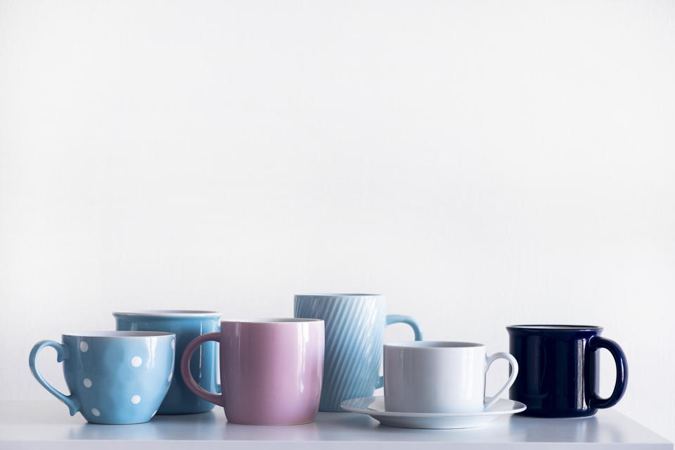 Assorted mugs in different styles and sizes aligned on a surface