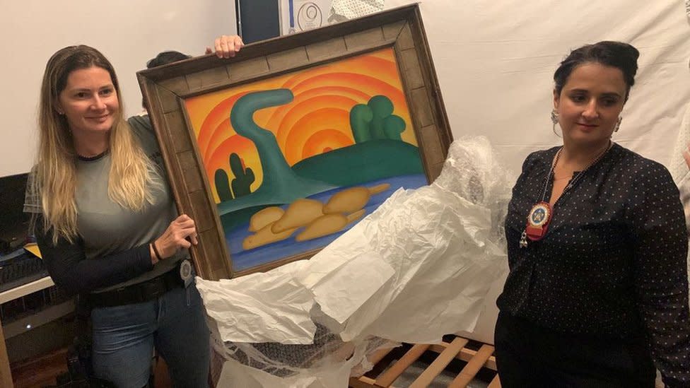 Investigador de la Policía Civil y un delegado sostienen la pintura de la artista Tarsila do Amaral titulada 