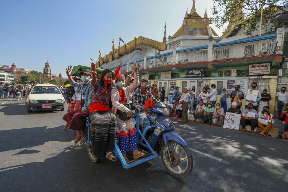 Demonstrator flash three-fingered salutes, a symbol of resistance, during a protest against the military coup in Yangon, Myanmar, Wednesday, Feb. 10, 2021. Protesters continued to gather Wednesday in Yangon breaching Myanmar's new military rulers' decrees that effectively banned peaceful public protests in the country's two biggest cities. (AP Photo)