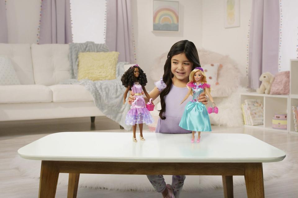 This image released by Mattel shows a child playing with Teresa, a My First Barbie deluxe set, new dolls made specifically for children as young as 3. They are 13.5 inches tall, with a broader waste that de-emphasizes the bust line, with flesh-tone modesty undergarments permanently attached. (Mattel via AP)