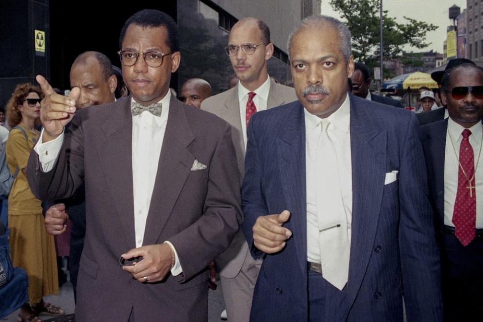 The Rev. Calvin Butts, left, makes a point in a show of support for the defendants of the Central Park trial outside the New York State Supreme Court in Manhattan in New York on July 24, 1990. (AP Photo/Richard Drew, File)