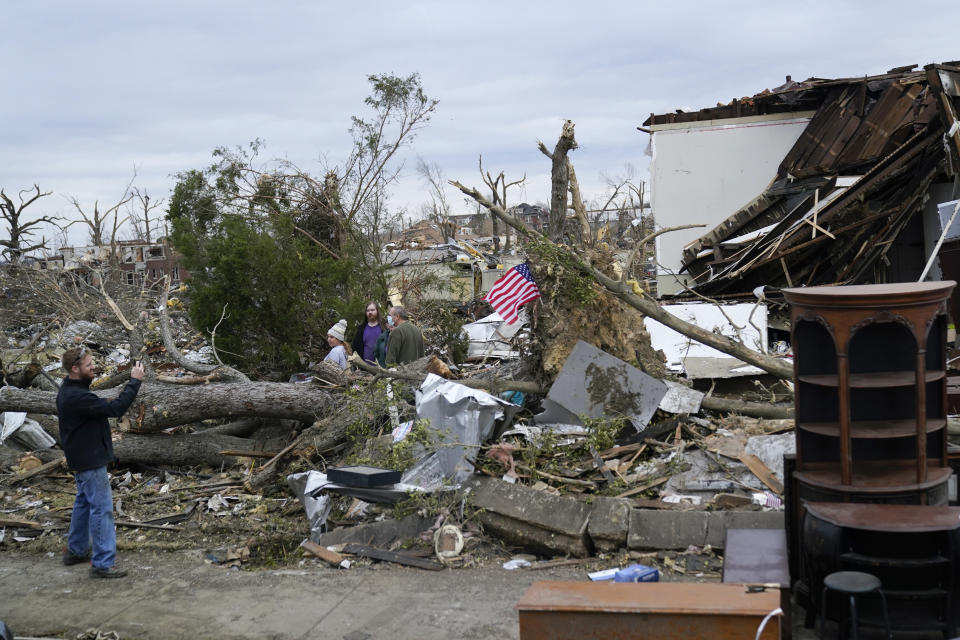 People survey storm damage from tornadoes and extreme weather in Mayfield, Ky., Wednesday, Dec. 15, 2021. (AP Photo/Andrew Harnik)