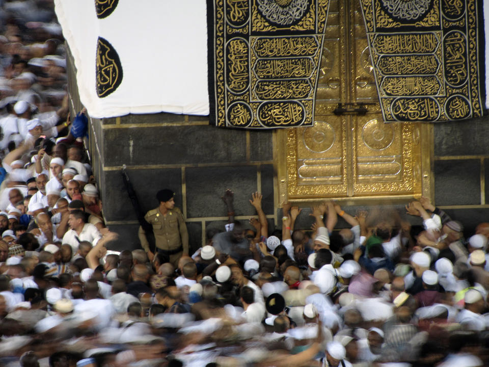 Muslim pilgrims touch the golden door of the the Kaaba, the cubic building at the Grand Mosque, ahead of the Hajj pilgrimage in the Muslim holy city of Mecca, Saudi Arabia, Wednesday, Aug. 7, 2019. The hajj occurs once a year during the Islamic lunar month of Dhul-Hijja, the 12th and final month of the Islamic calendar year. (AP Photo/Amr Nabil)