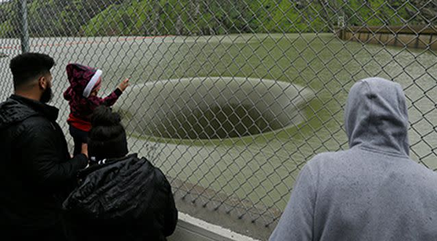 People stop to watch water flow into the iconic Glory Hole spillway at the Monticello Dam on lake Berryessa north of San Fransisco. Photo: AP