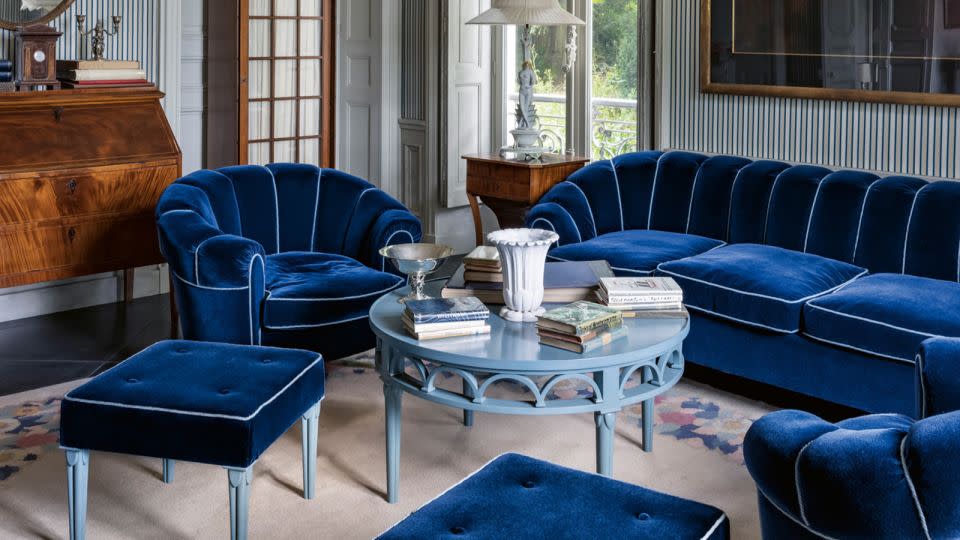 Throughout Villa Louveciennes, Lagerfeld took inspiration from his previous residences — what Kalt describes as "a compendium of his previous passions." Pictured above, a living space outfitted in lush blue velvets. - Jerome Galland/Courtesy Thames & Hudson