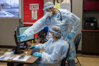 FILE - In this Nov. 13, 2020, file photo, Physician assistant Steven Oginsky, top, and registered nurse Kim Alder work inside the Hackley Community Care COVID-19 triage room at 2700 Baker Street in Muskegon Heights, Mich. U.S. hospitals slammed with COVID-19 patients are trying to lure nurses and doctors out of retirement and recruiting nursing students and new graduates who have yet to earn their licenses. (Cory Morse/The Grand Rapids Press via AP, File)