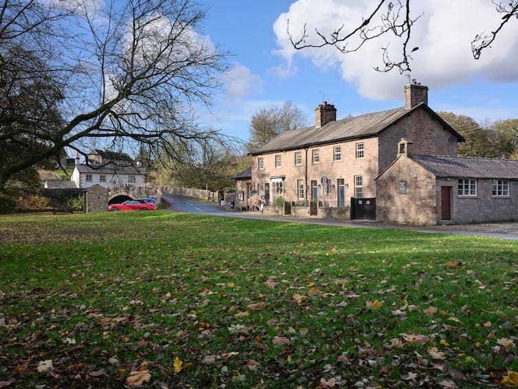 A row of houses in a northern English village next to a bridge.