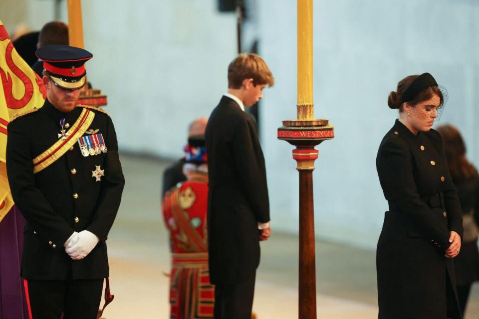 Britain's Prince Harry (L), the Duke of Sussex, James (C), Viscount Severn and Britain's Princess Eugenie of York (R) hold a vigil around Queen Elizabeth II's coffin, draped in the Royal Standard with the Imperial Crown of State and the Sovereign's Orb and Scepter, in state on the catafalque in Westminster Hall, at the Palace of Westminster in London on September 16, 2022, ahead of her funeral on Monday.  - Queen Elizabeth II will rest in state in Westminster Hall inside the Palace of Westminster until 05:30 GMT on September 19, hours before her funeral, with huge queues outside her coffin to return her tribute.  (Photo by Ian Vogler/POOL/AFP) (Photo by IAN VOGLER/POOL/AFP via Getty Images)