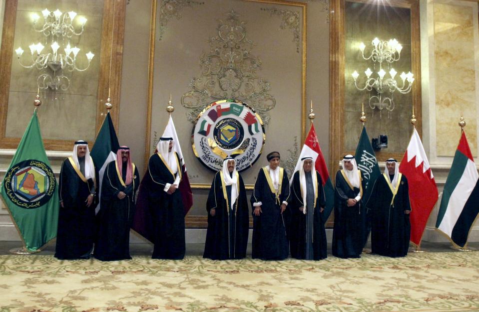 FILE - Officials gather for a group photograph, with Qatar's emir, Sheikh Tamim bin Hamad Al Thani, third left, and Kuwait's emir, Sheikh Sabah Al Ahmad Al Sabah, center, at the Gulf Cooperation Council summit in Kuwait City, Dec. 5, 2017. Qatar will be on the world stage like it never has before as the small, energy-rich nations hosts the 2022 FIFA World Cup beginning this November. (AP Photo/Jon Gambrell, File)